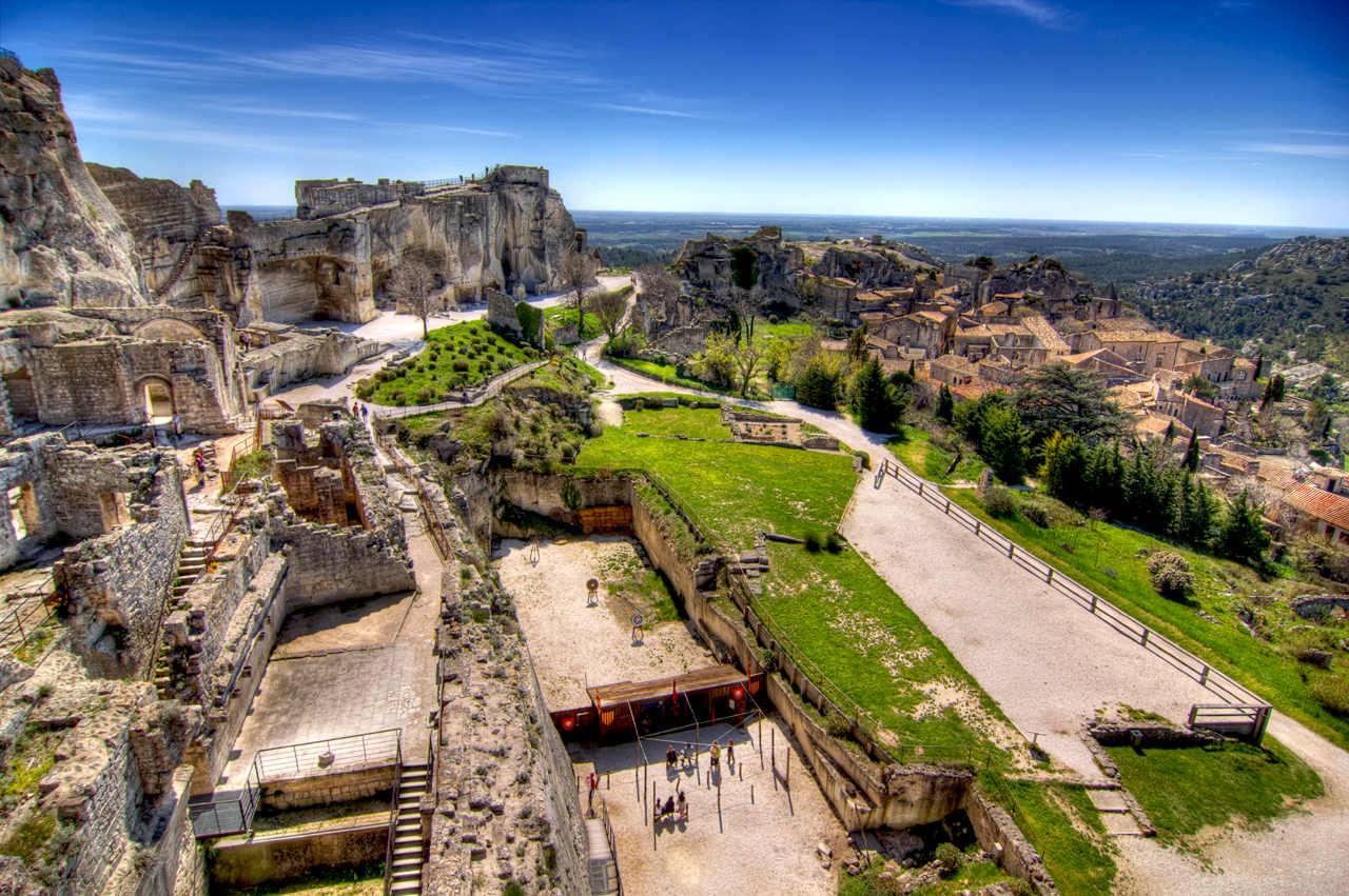 Uitzicht vanaf de hoogte van het kasteel van Les Baux-de-Provence over de resten van de vesting, de middeleeuwse belegeringswerktuigen en de dorpsdaken