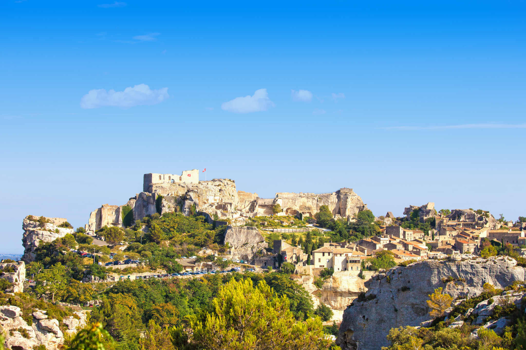 Het middeleeuwse dorp Les Baux-de-Provence en zijn kasteelruïne boven de heuvels van de Alpilles onder een blauwe lucht