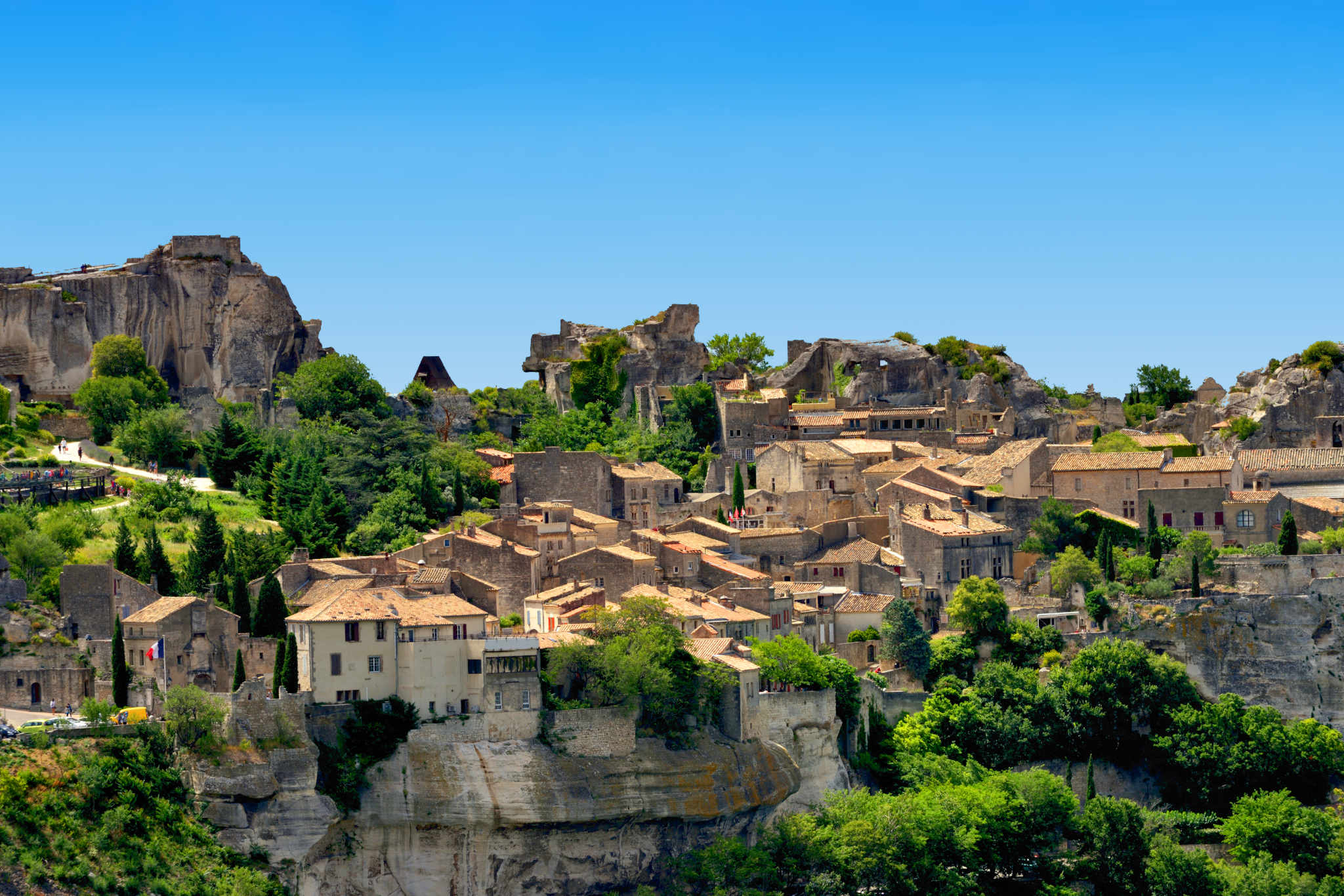Steinhäuser des Dorfes Les Baux-de-Provence am Rand der Kalksteinfelsen, im Hintergrund die Reste der Burg